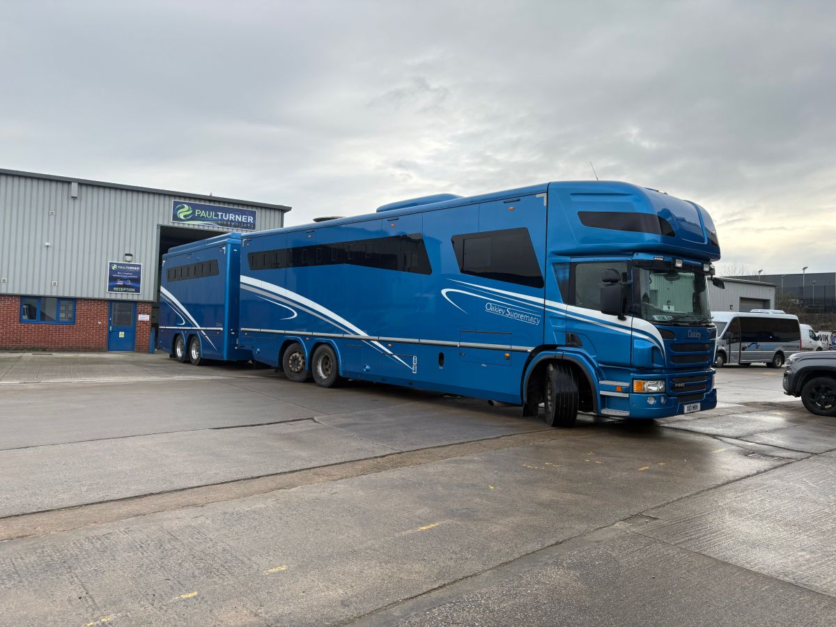 Blue horsebox and trailer in outdoor setting before wrapping.